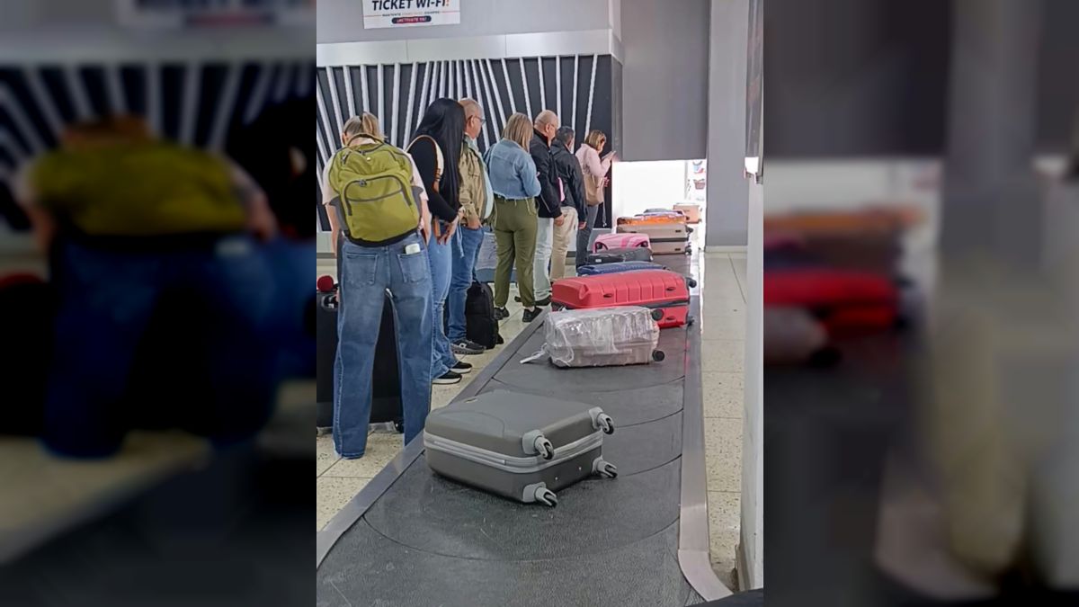 Pasajeros esperan su equipaje junto a la cinta transportadora del aeropuerto