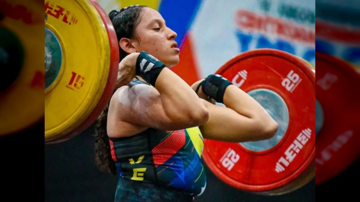 Una pesista de la selección venezolana sostiene la barra a la altura de los hombros durante un levantamiento
