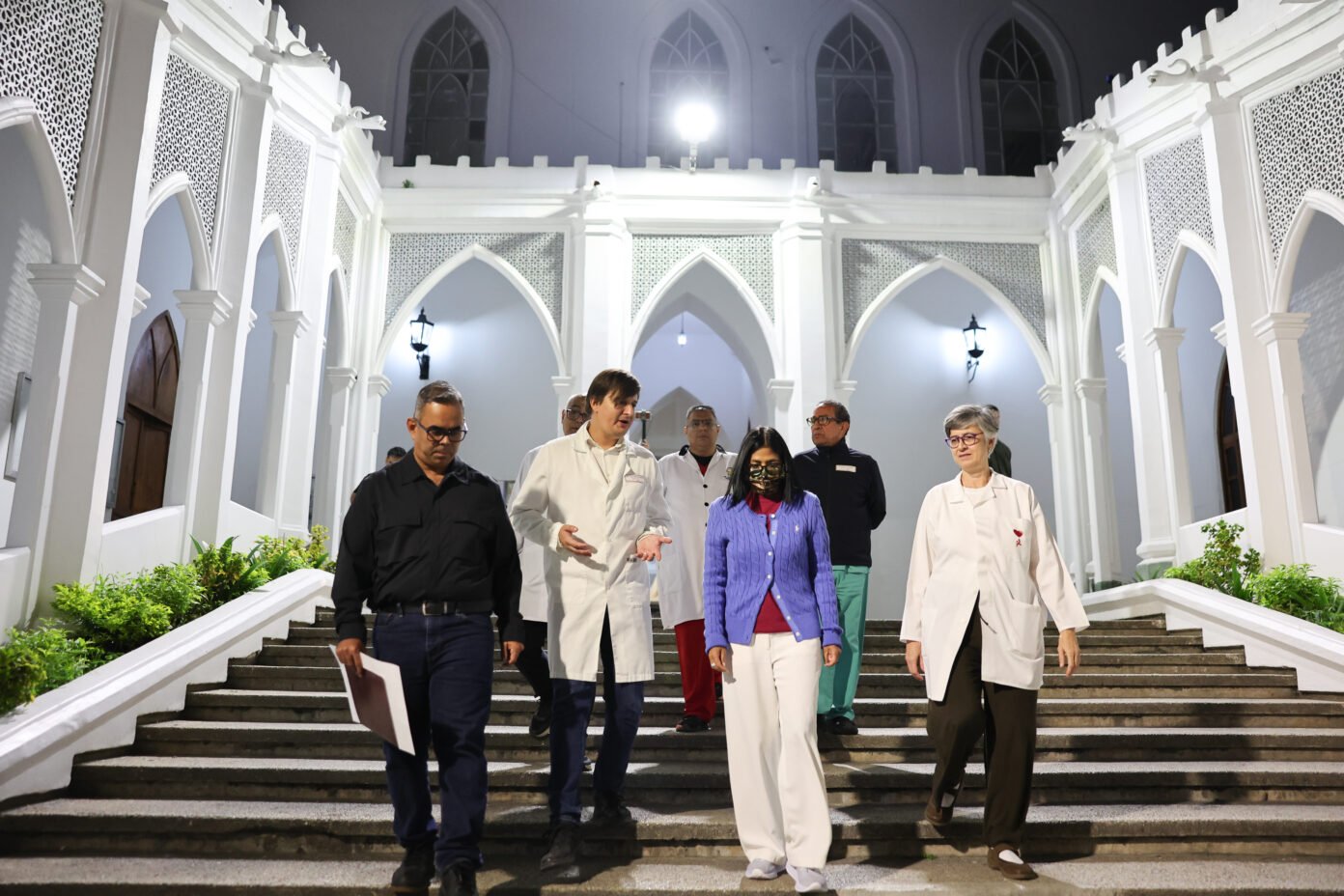 Delcy Rodríguez baja la escalera del patio del edificio patrimonial del Hospital Vargas junto a médicos y funcionarios