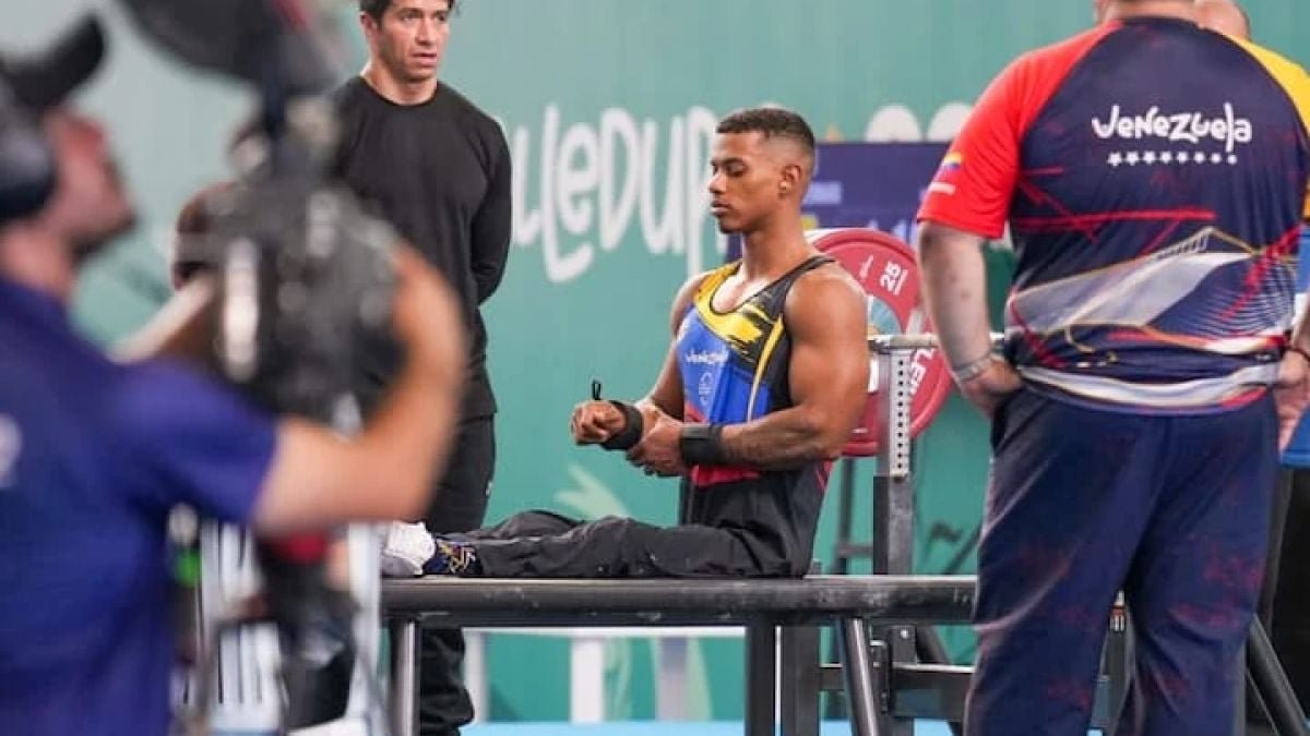 Un pesista de la selección venezolana de parapotencia se concentra sentado en el banco de competencia