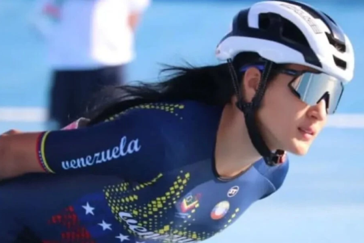 Una patinadora de la selección venezolana, con casco blanco y lentes de sol, inclinada en posición de carrera