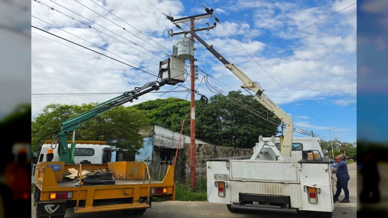 Dos camiones grúa de Corpoelec instalan un transformador en un poste de una calle de Barinas