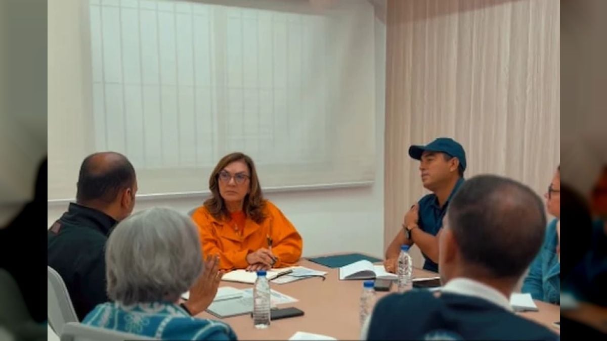 Jacqueline Faria en una reunión de trabajo alrededor de una mesa