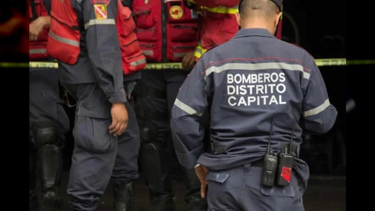 Bomberos del Distrito Capital junto a la cinta de acordonamiento en el lugar del incendio