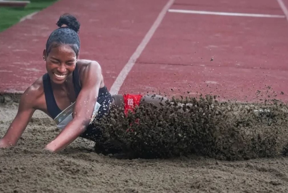 Una atleta cae en el foso de arena durante una prueba de salto