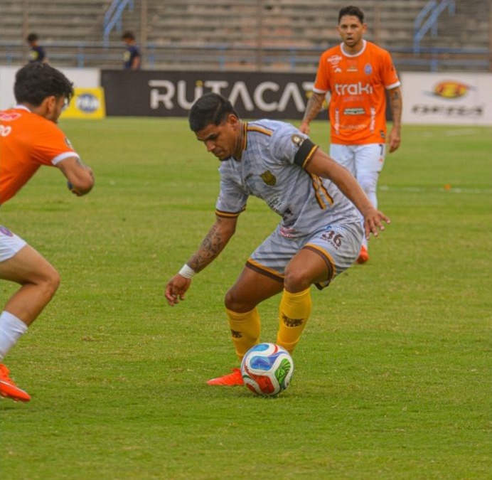 Un futbolista conduce el balón ante dos jugadores de Deportivo La Guaira
