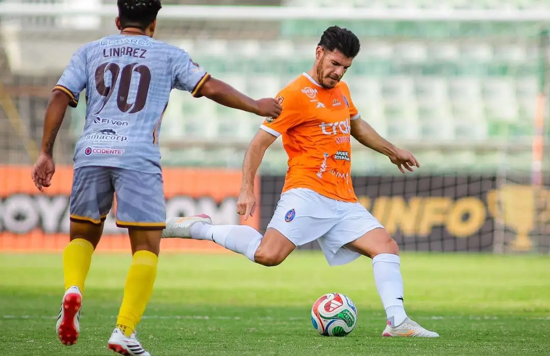 Un jugador de Deportivo La Guaira patea el balón ante un rival