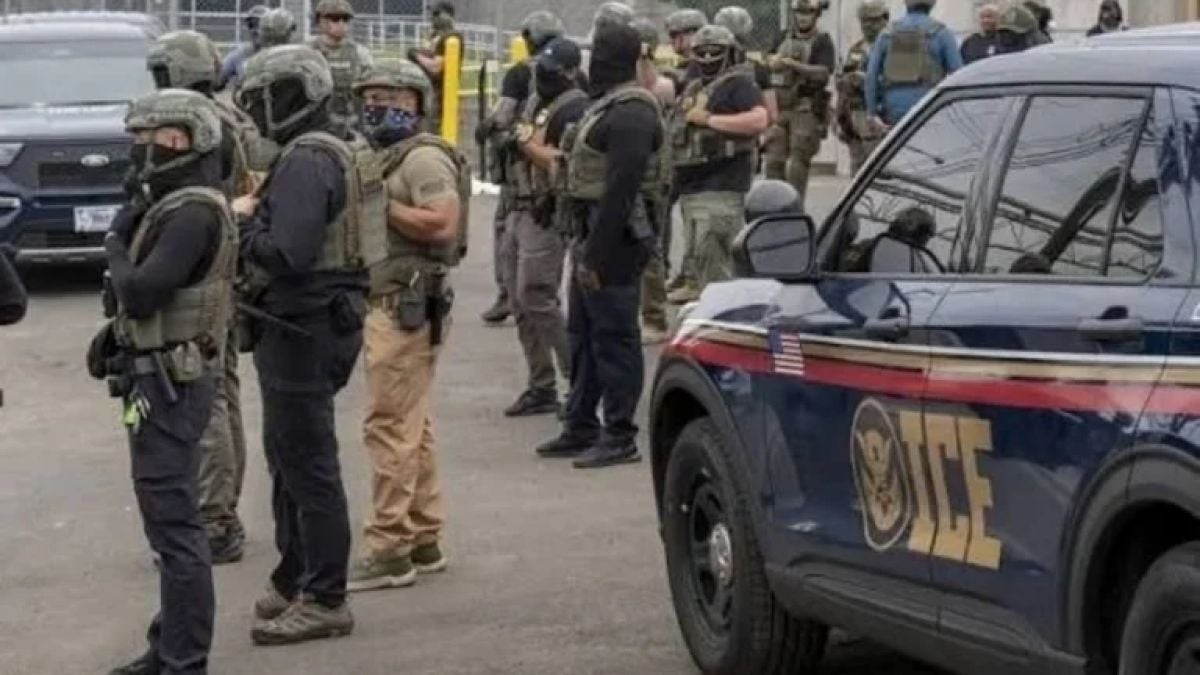 Agentes con chalecos tácticos junto a un vehículo de ICE