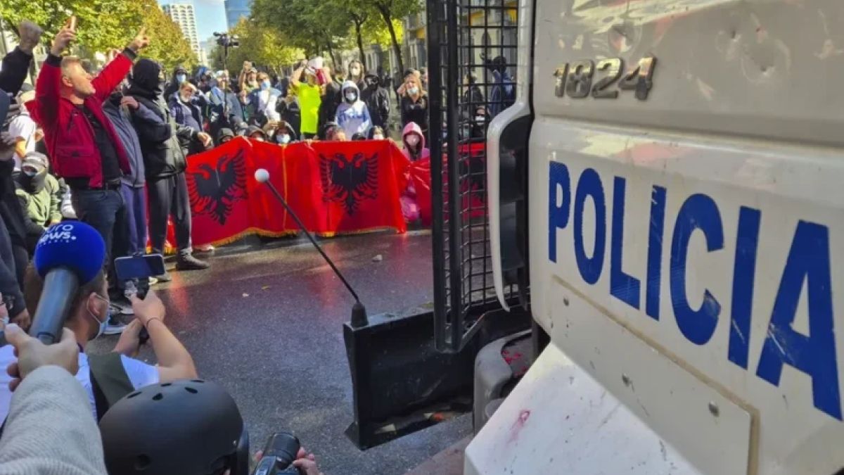 Manifestantes con banderas de Albania frente a un vehículo de la policía en Tirana