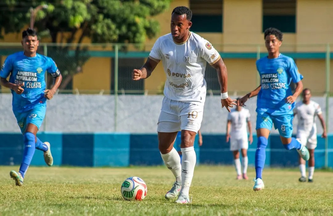 Futbolistas disputan un balón en un partido