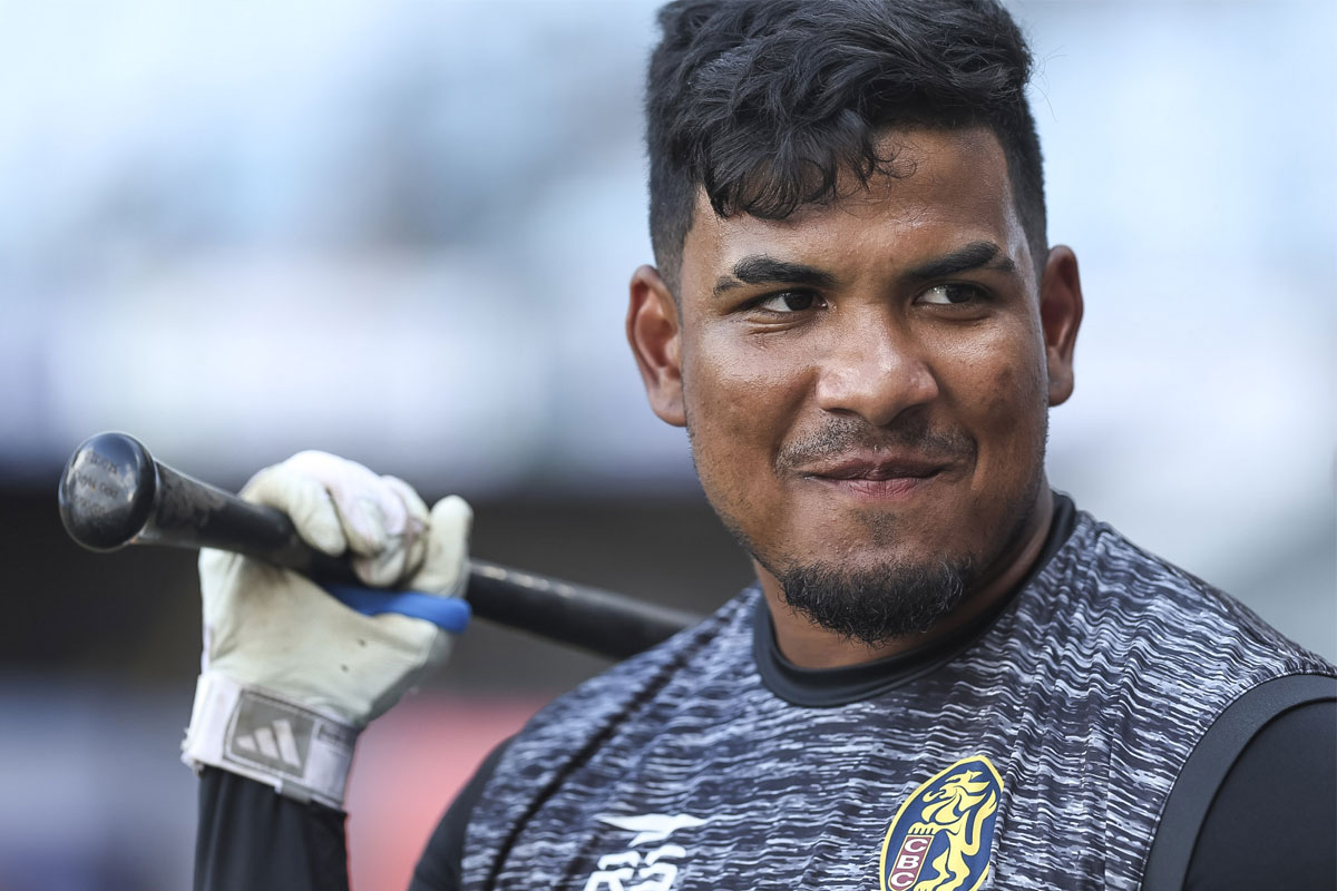 Un pelotero con un bate sonríe