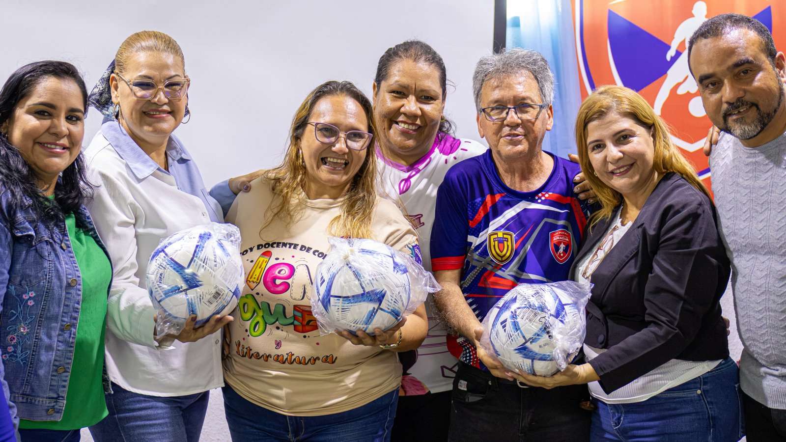 Siete personas posan con balones de fútbol