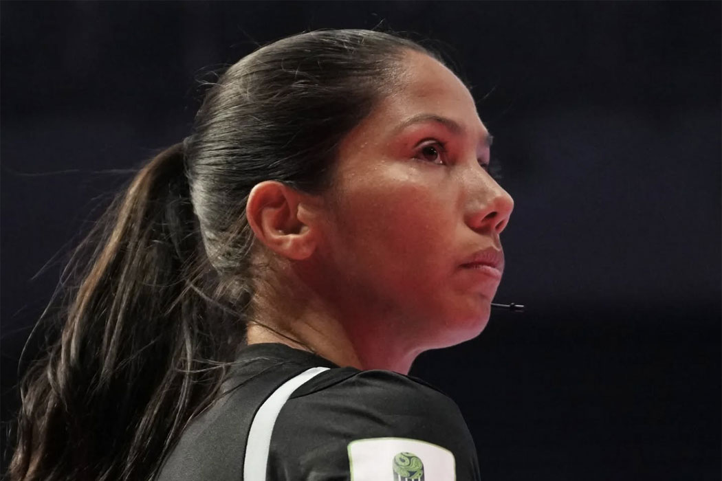 Una árbitra de futsal de perfil en una cancha