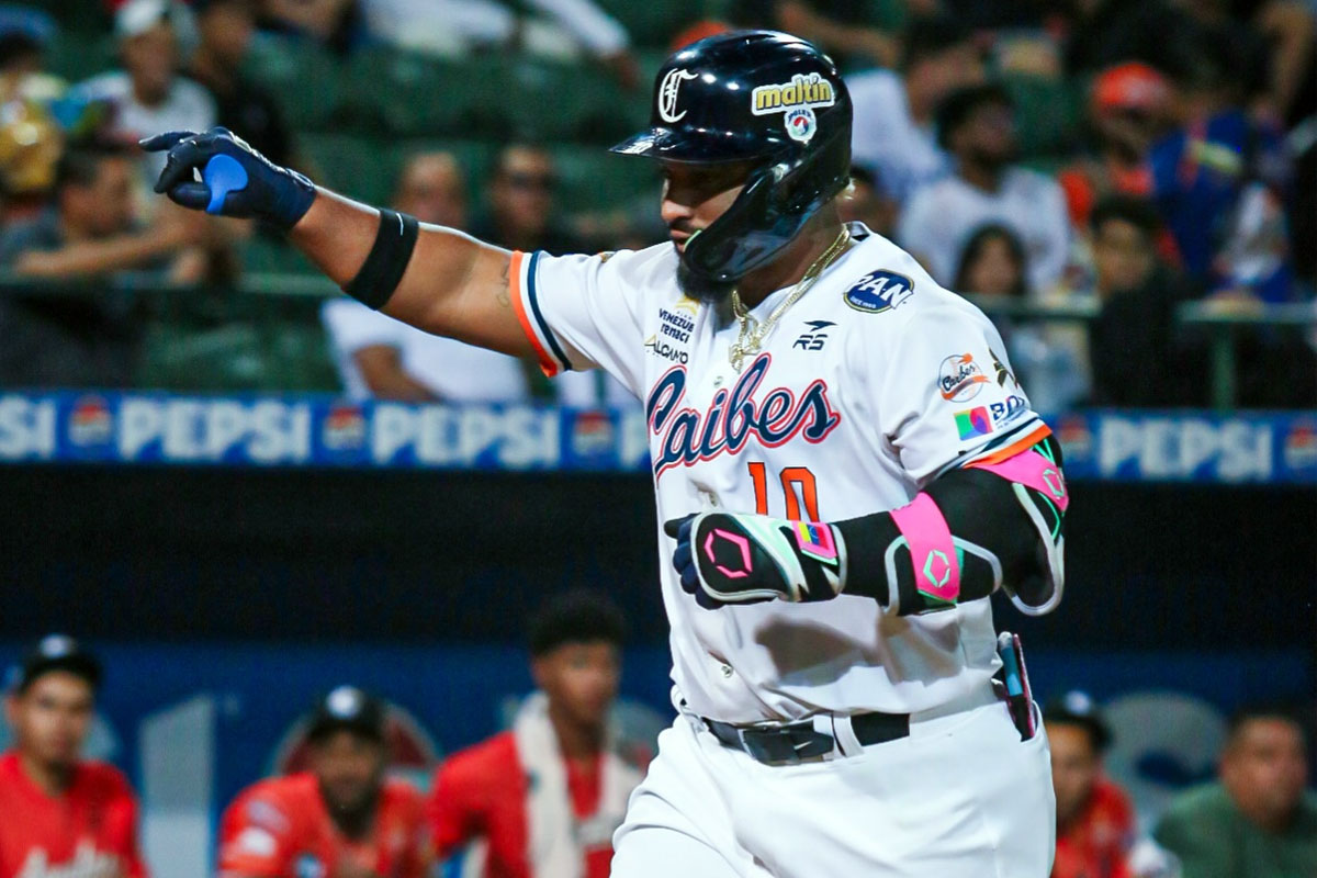 Un jugador de Caribes con el número 10 y casco negro extiende el brazo izquierdo