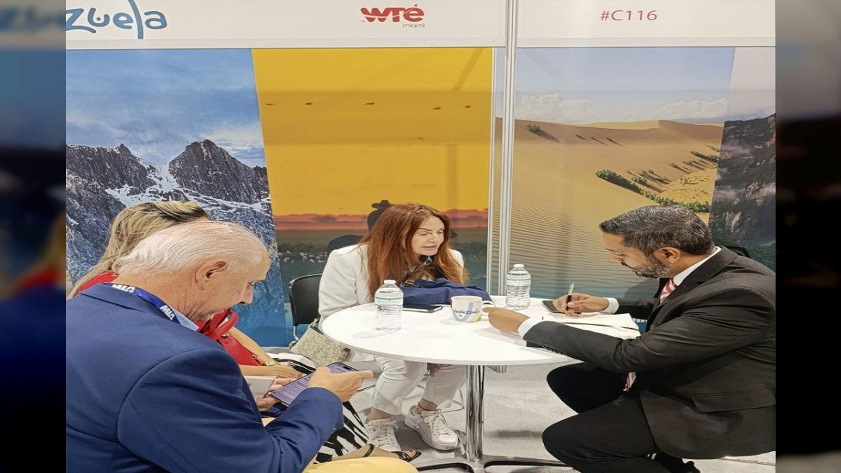 Cuatro personas reunidas en una mesa de un stand de la World Travel Expo Miami